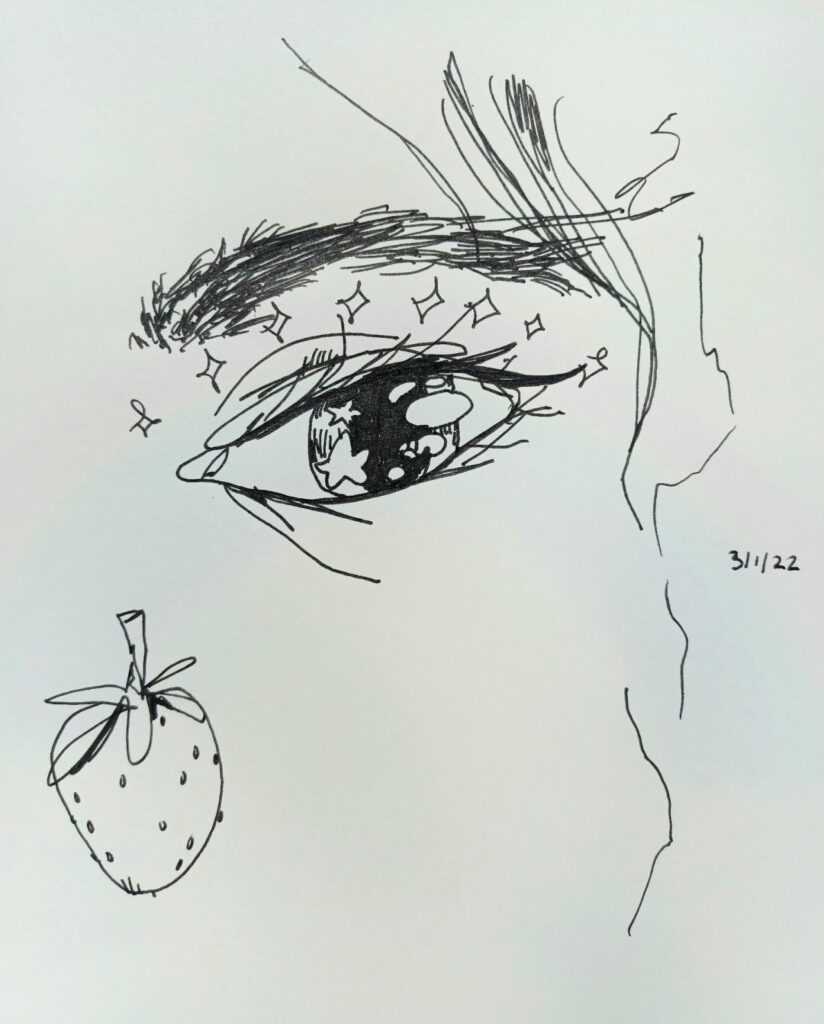 A pen drawing in a sketchbook of an eye and a strawberry.