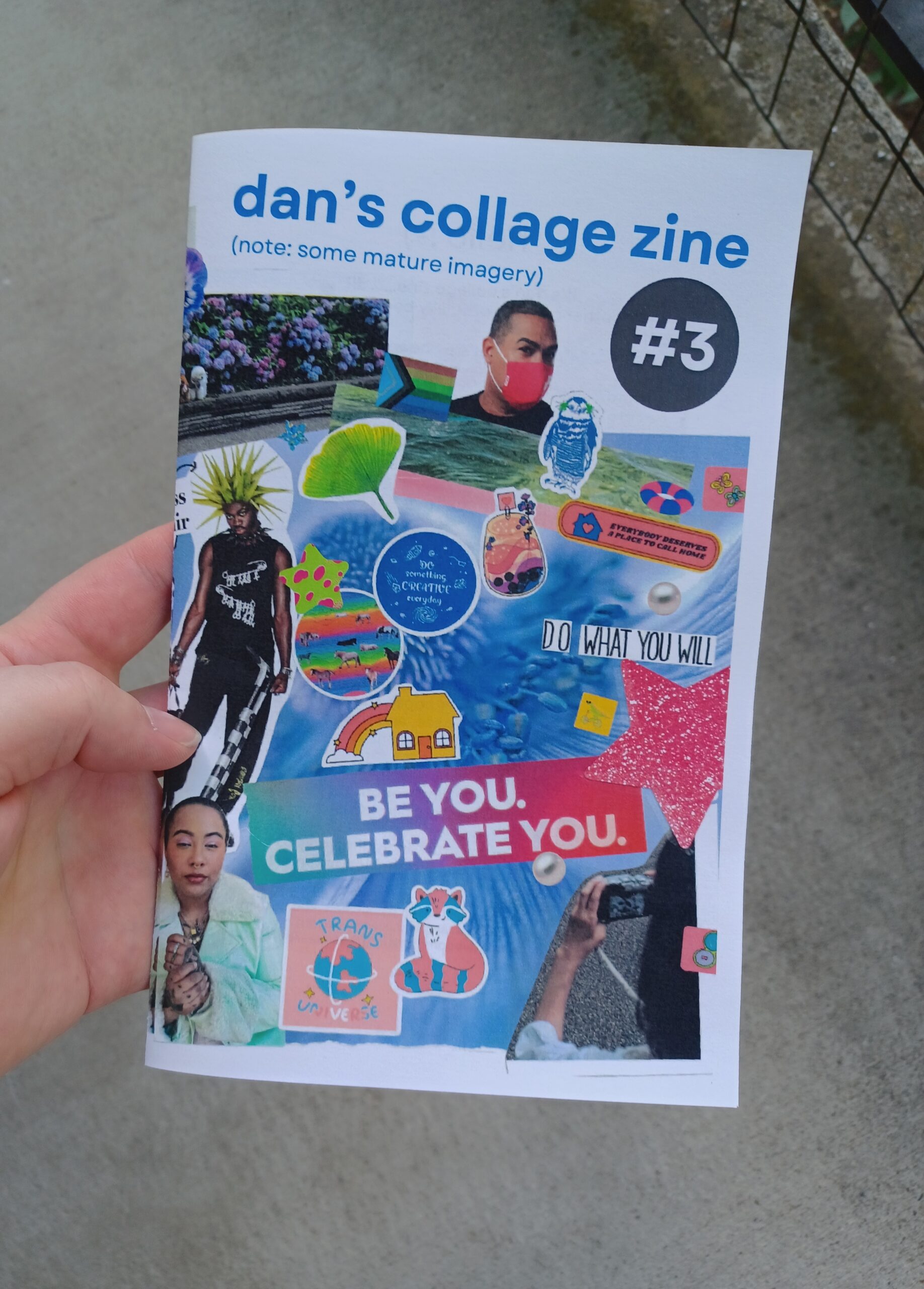 My hand holding a full size zine with the title "dan's collage zine #3" in front of a concrete background. Half of a collage is visible on the cover.